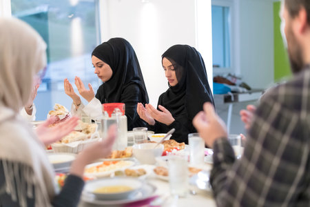 Muslim family making iftar dua to break fasting during Ramadan.の写真素材
