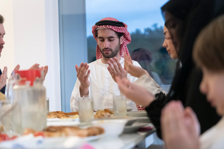 Muslim family making iftar dua to break fasting during Ramadan.の写真素材
