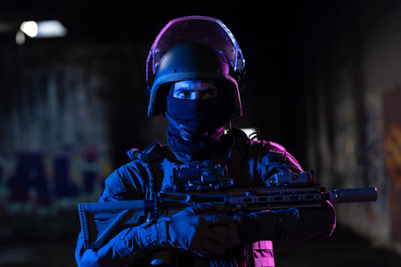 Army soldier in Combat Uniforms with an assault rifle and combat helmet night mission dark...