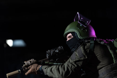Army soldier in Combat Uniforms with an assault rifle and combat helmet night mission dark background. Blue and purple gel light effect.の写真素材