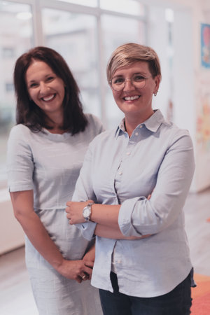 Portrait of a two teacher in a preschool institution, in the background of the classroomsの写真素材