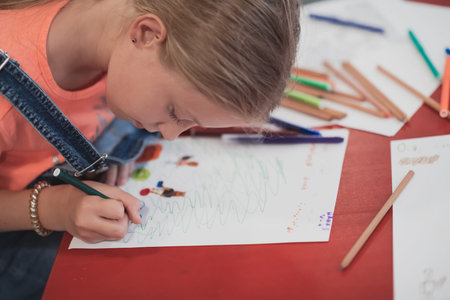 Creative kids sitting in a preschool institution, draw and have fun while they get an education