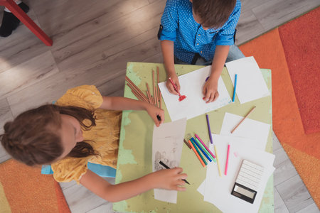 Creative kids sitting in a preschool institution, draw and have fun while they get an educationの写真素材