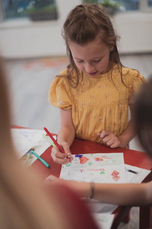 Creative kids sitting in a preschool institution, draw and have fun while they get an education
