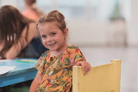 Creative kids sitting in a preschool institution, draw and have fun while they get an education