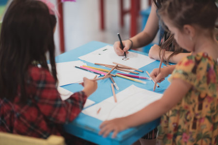 Creative kids sitting in a preschool institution, draw and have fun while they get an educationの写真素材