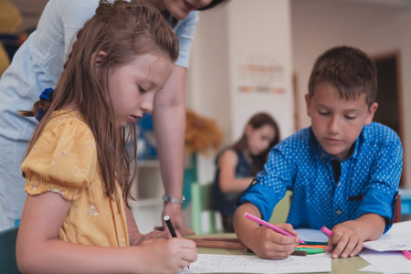 Creative kids during an art class in a daycare center or elementary school classroom drawing with...
