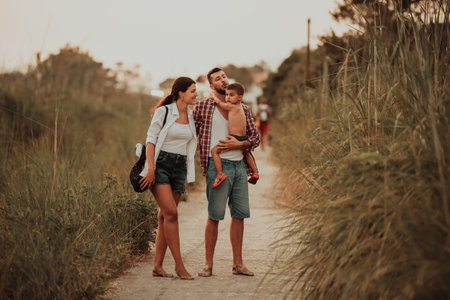 The family walks an idyllic path surrounded by tall grass. Selective focusの写真素材