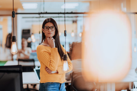 Female boss, manager executive posing in a modern startup office while being surrounded by her...