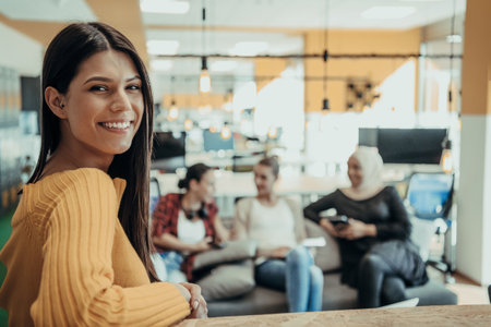 Female boss, manager executive posing in a modern startup office while being surrounded by her coworkers, team.の写真素材