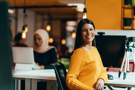 A young woman using a camera to present her business with online clientsの写真素材