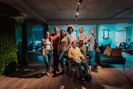 Businesswoman in a wheelchair on break in a modern office with her team in the background