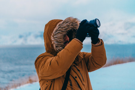 A photographer in the cold Skavdinava regions tries to take a photo for journalism in a strong winter stormの写真素材