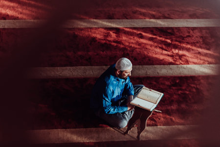 A Muslim reads the holy Islamic book Quraqn in a modern grand mosque during the Muslim holy month of...