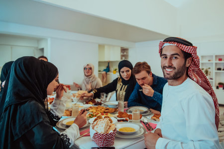 Muslim family having Iftar dinner drinking water to break feast. Eating traditional food during...