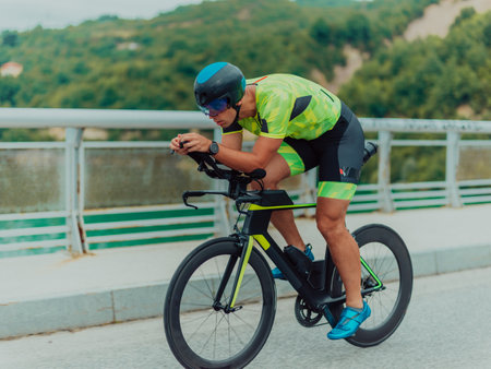 Full length portrait of an active triathlete in sportswear and with a protective helmet riding a bicycle. Selective focusの写真素材