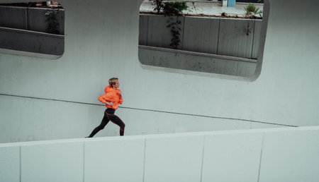 Women in sports clothes running in a modern urban environment. The concept of a sporty and healthy...
