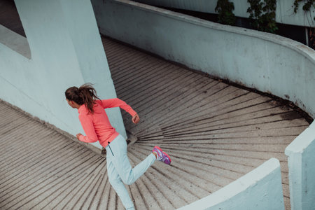 Women in sports clothes running in a modern urban environment. The concept of a sporty and healthy...