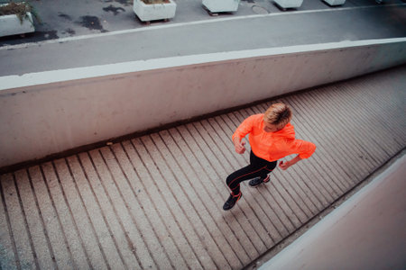 Women in sports clothes running in a modern urban environment et night time. The concept of a sporty and healthy lifestyleの写真素材