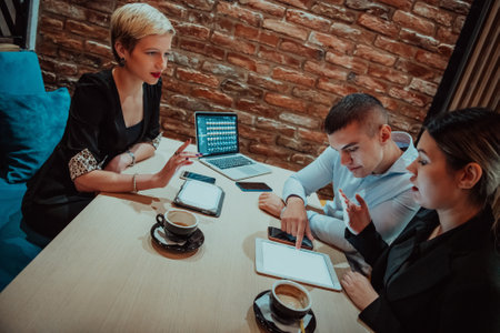 Happy businesspeople smiling cheerfully during a meeting in a coffee shop. Group of successful business professionals working as a team in a multicultural workplace.の写真素材