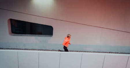 Women in sports clothes running in a modern urban environment et night time. The concept of a sporty...
