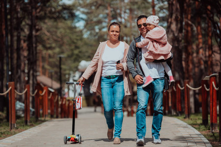 Family fun in the park. Happy family spending time in park and playing with their daughterの写真素材