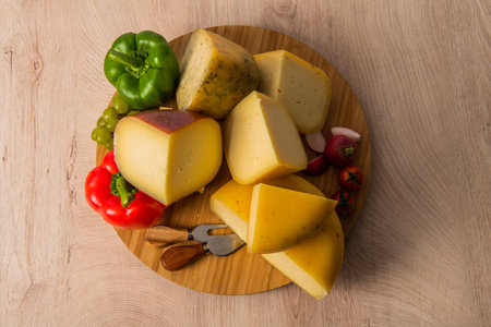 Bosnian traditional cheese served on a wooden container with peppers, parade and onions isolated on...