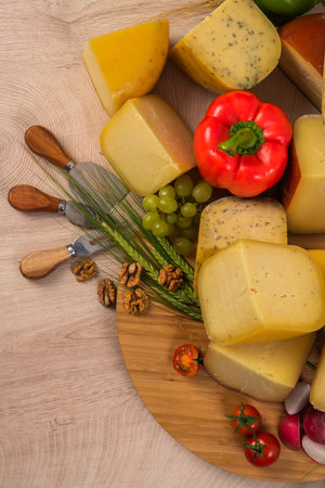 Bosnian traditional cheese served on a wooden container with peppers, parade and onions isolated on a white backgroundの写真素材