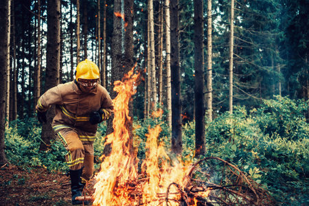 firefighter hero in action danger jumping over fire flame to rescue and saveの写真素材
