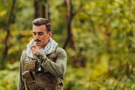 Terrorist have a break and smoke cigarette in forest during battle