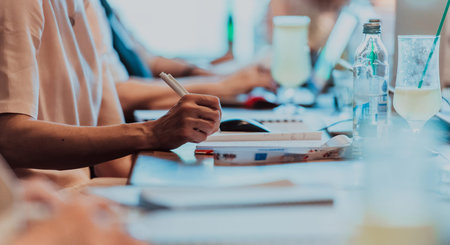 Closeup shot of business people hands using pen while taking notes on education training during business seminar at modern conference roomの写真素材