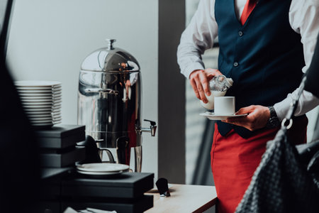 The waiter preparing coffee for hotel guests. Close up photo of service in modern hotelsの写真素材