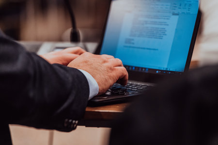 Close up photo of a businessman typing on a laptopの写真素材
