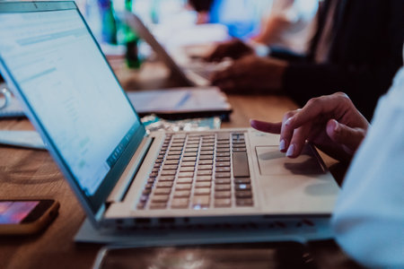 Close up photo of a womans hand using on a laptop at a seminarの写真素材