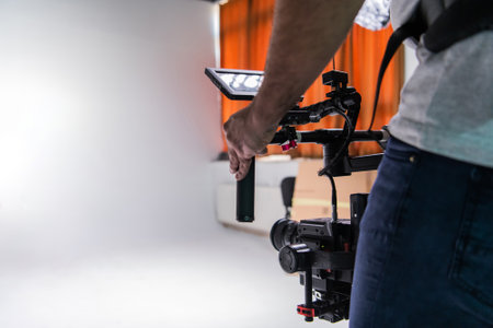 The cameraman in the studio using a professional camera with a stabilizerの写真素材