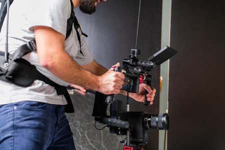 The cameraman in the studio using a professional camera with a stabilizerの写真素材