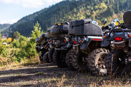 Close-up tail view of ATV quad bike on dirt country road. Dirty wheel of AWD all-terrain vehicle. Travel and adventure concept.の写真素材