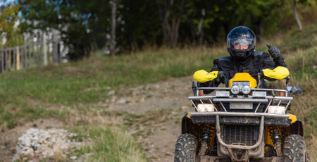 Adventurous driving of ATV motorbikes. A man drives a quad bike on dangerous roadsの写真素材