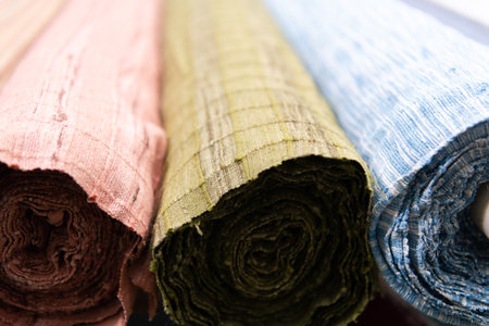 Collection of fashionable fabrics. Samples of different natural fabrics for sewing a fashion collection of clothes. Large selection of fabrics in the store or tailor warehouse.の写真素材