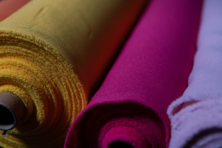 Collection of fashionable fabrics. Samples of different natural fabrics for sewing a fashion collection of clothes. Large selection of fabrics in the store or tailor warehouse.の写真素材