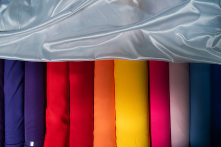 Collection of fashionable fabrics. Samples of different natural fabrics for sewing a fashion collection of clothes. Large selection of fabrics in the store or tailor warehouse.の写真素材