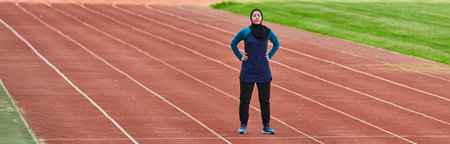 A muslim woman in a burqa sports muslim clothes running on a marathon course and preparing for...
