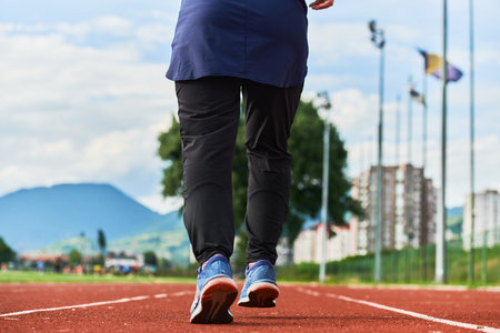 A muslim woman in a burqa sports muslim clothes running on a marathon course and preparing for upcoming competitionsの写真素材