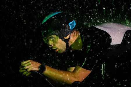 A triathlete braving the rain as he cycles through the night, preparing himself for the upcoming...