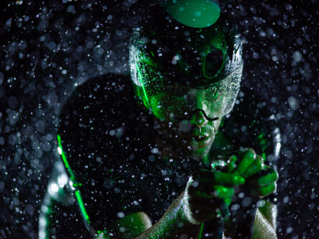 A triathlete braving the rain as he cycles through the night, preparing himself for the upcoming marathon. The blurred raindrops in the foreground and the dark, moody atmosphere in the background add to the sense of determination and grit shown by the athlete.の写真素材