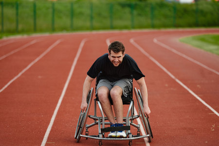 A person with disability in a wheelchair training tirelessly on the track in preparation for the Paralympic Gamesの写真素材