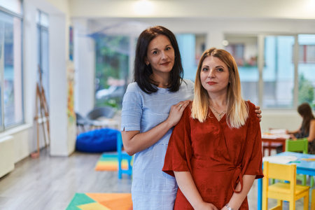 Portrait of a two teacher in a preschool institution, in the background of the classrooms
