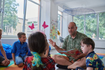 Reading time in an elementary school or kindergarten, a teacher reading a book to children in an...