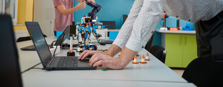 A student testing his new invention of a robotic arm in the laboratory, showcasing the culmination...