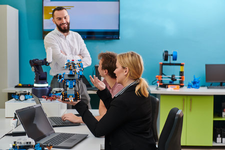 A group of colleagues working together in a robotics laboratory, focusing on the intricate fields of...